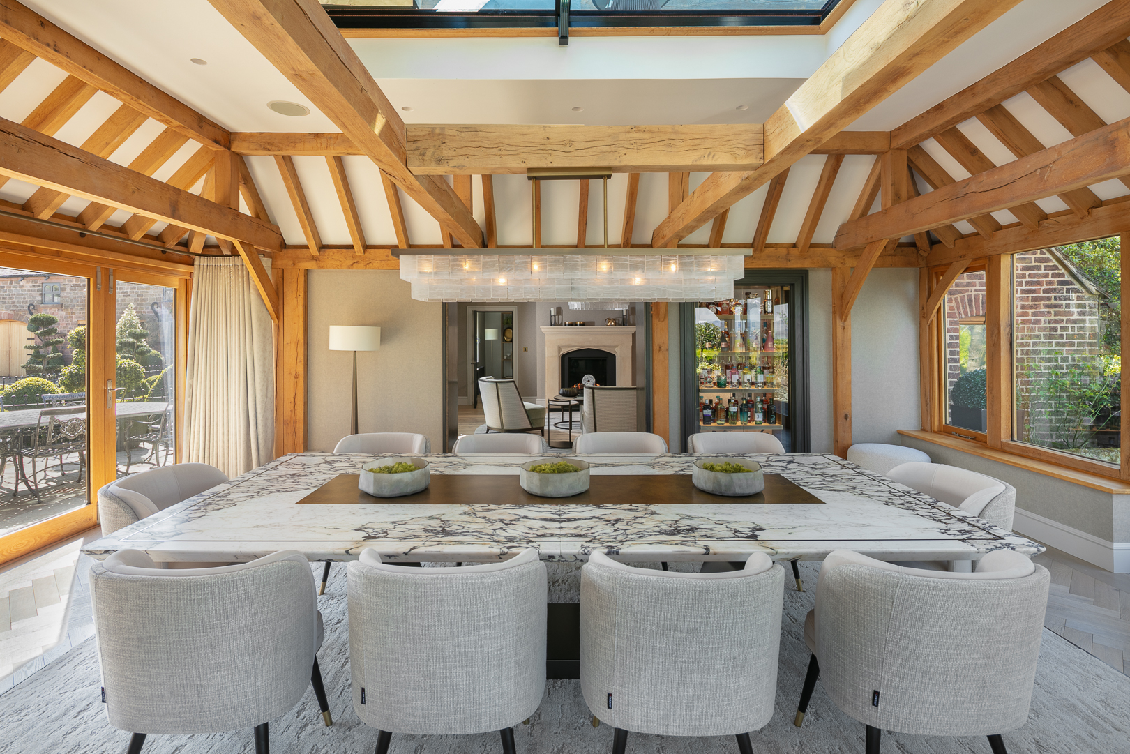 bespoke dining table for 10 with bronze inlay and liquid applied metal centre-piece and hand-blown chandelier