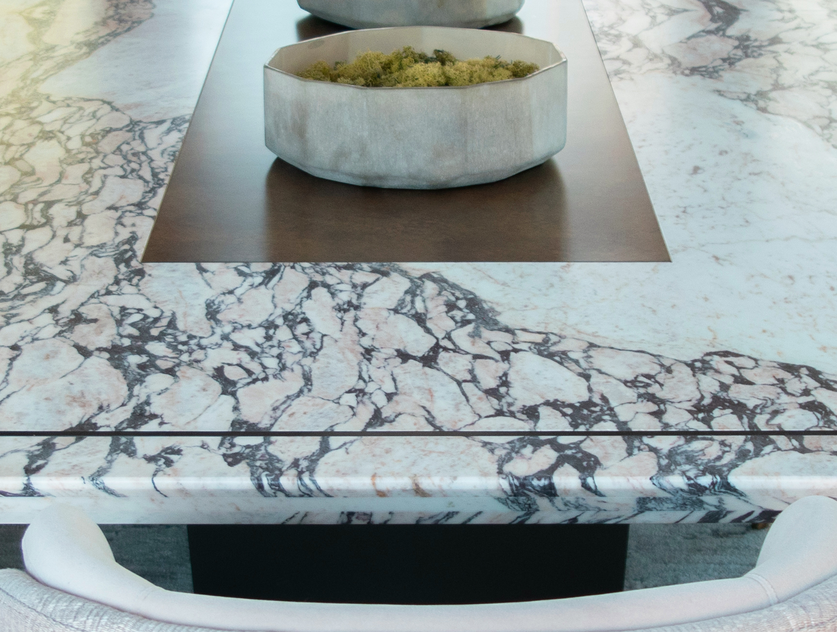Cold liquid applied metal centre runner and bronze frame inlay to a bespoke white marble dining table